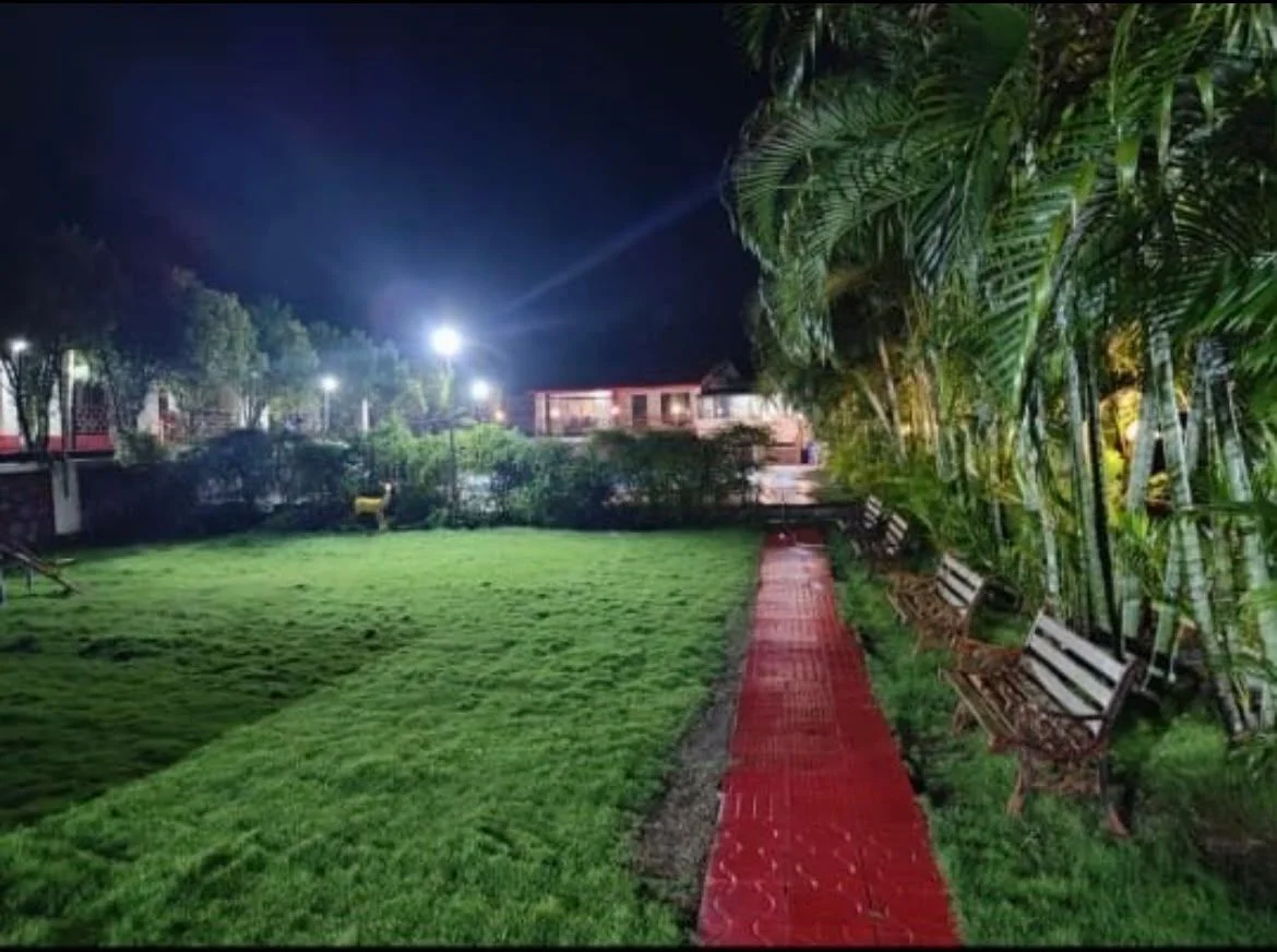 Lush green garden lawns lit at night at Kunal Resort