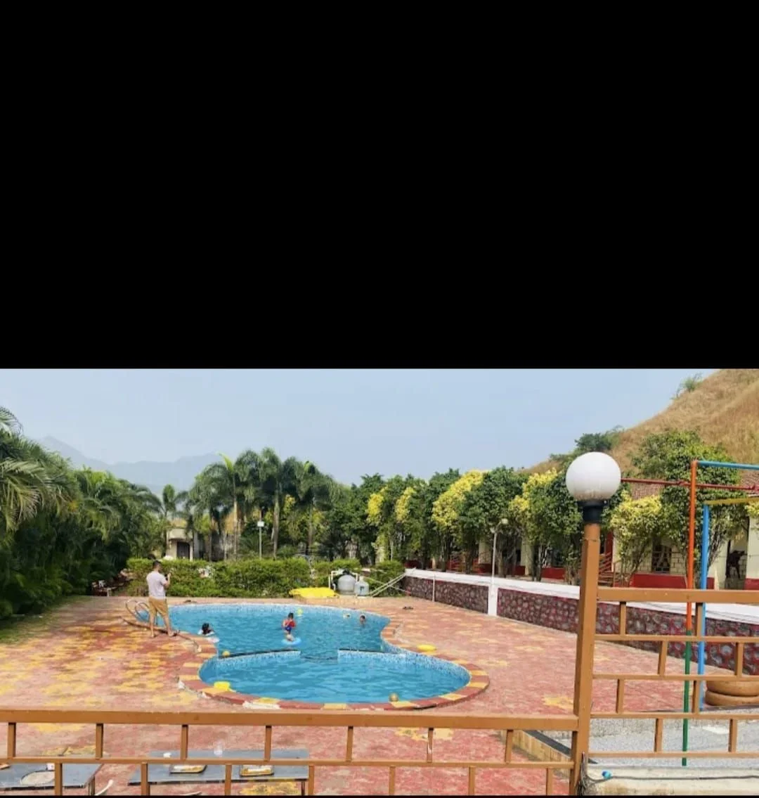 Crystal blue swimming pool in the daytime at Kunal Resort