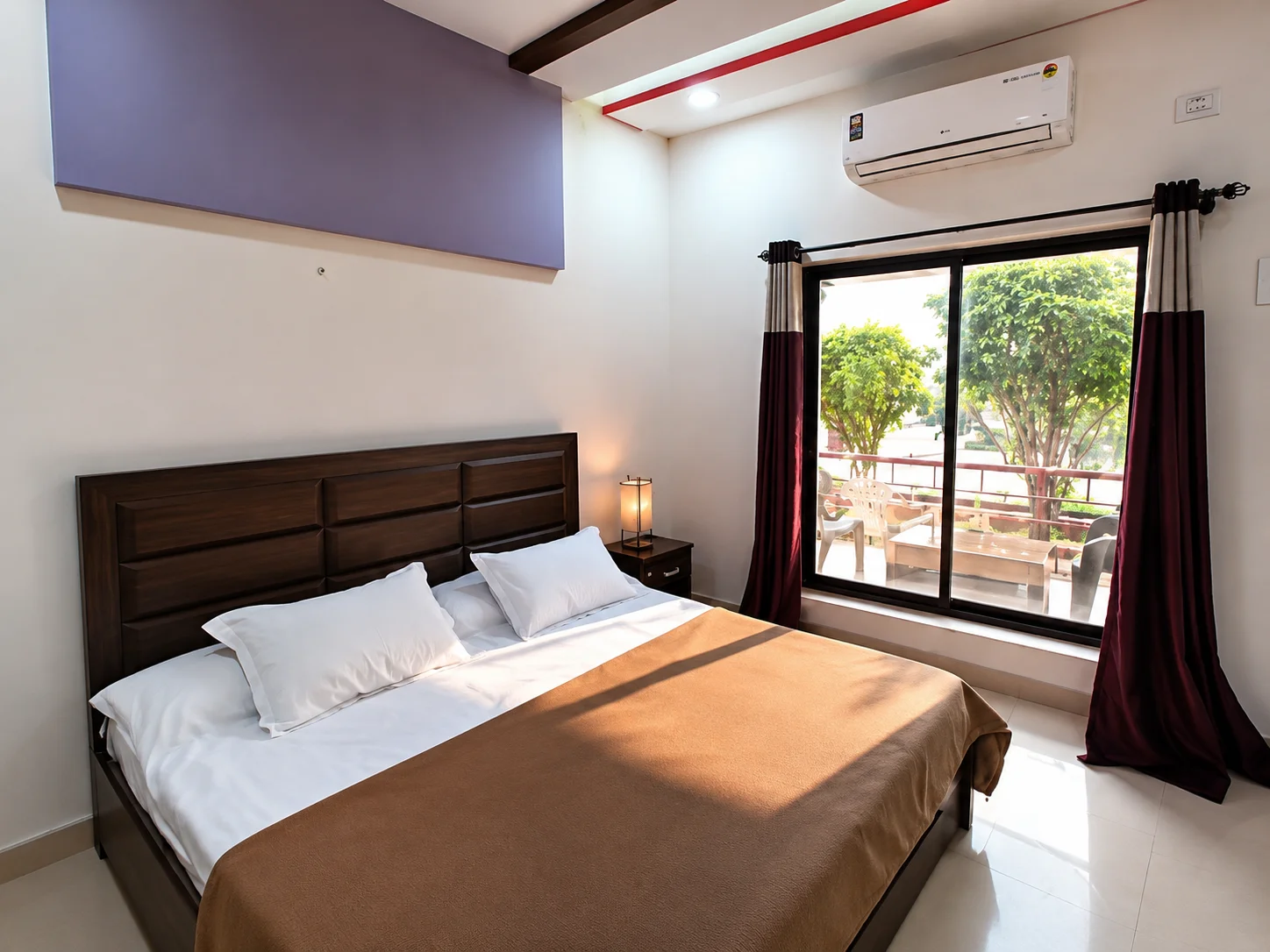 Premium AC Deluxe Room interior setup with balcony window