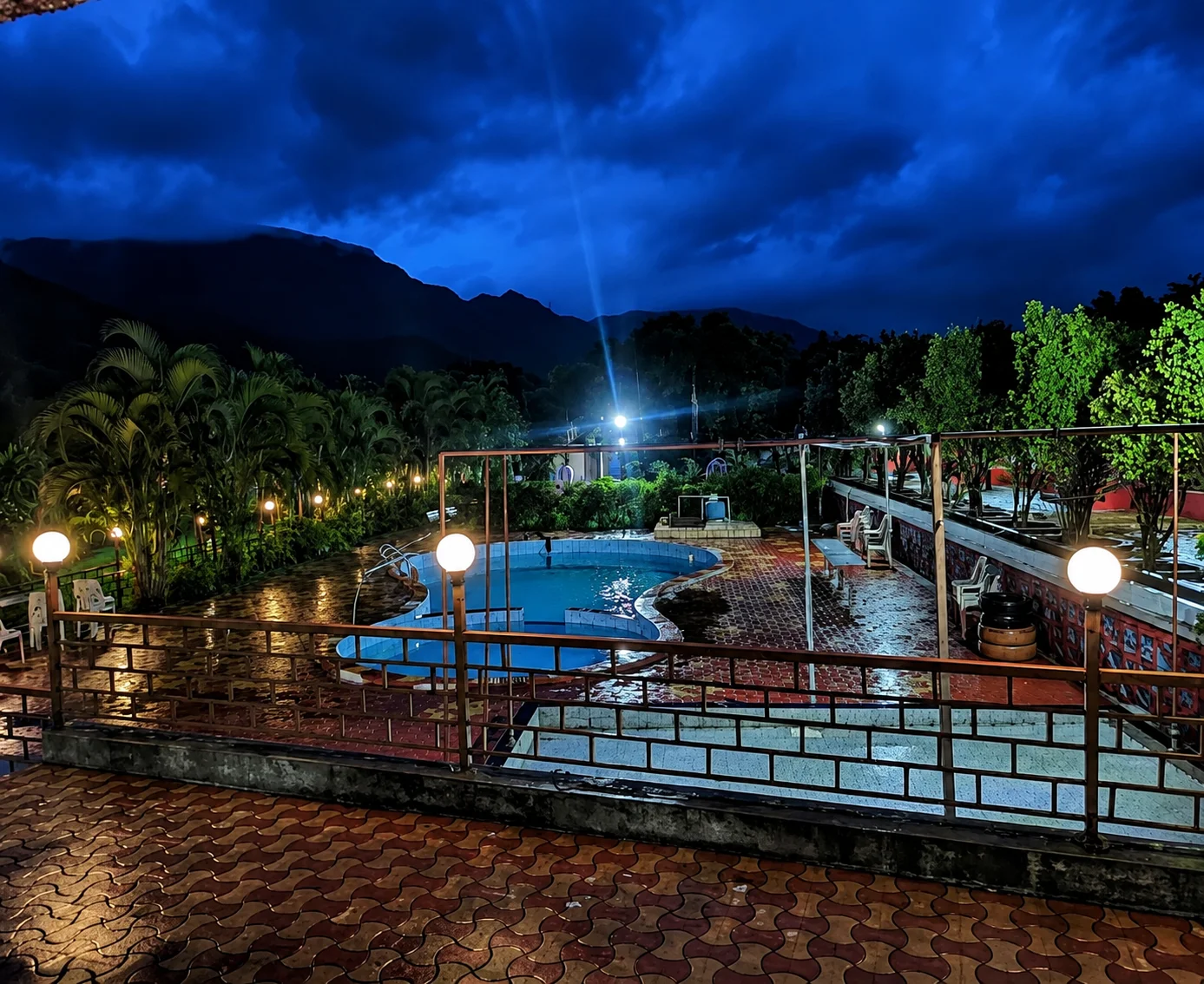 Illuminated outdoor swimming pool at night at Kunal Resort